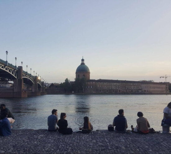 People sitting by Garonne river