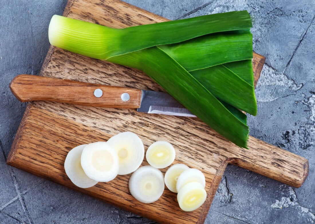 Leek on wooden cutting board and knife