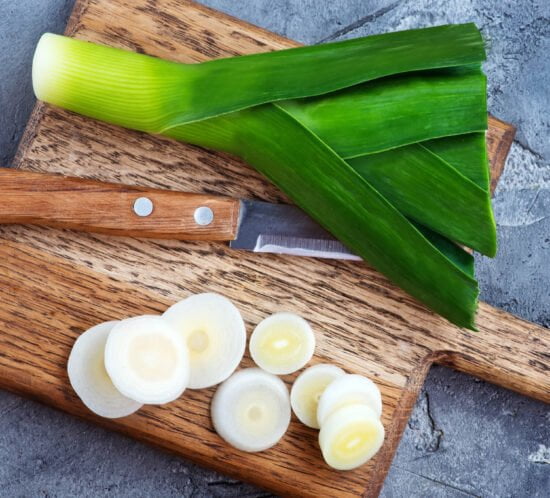 Leek on wooden cutting board and knife